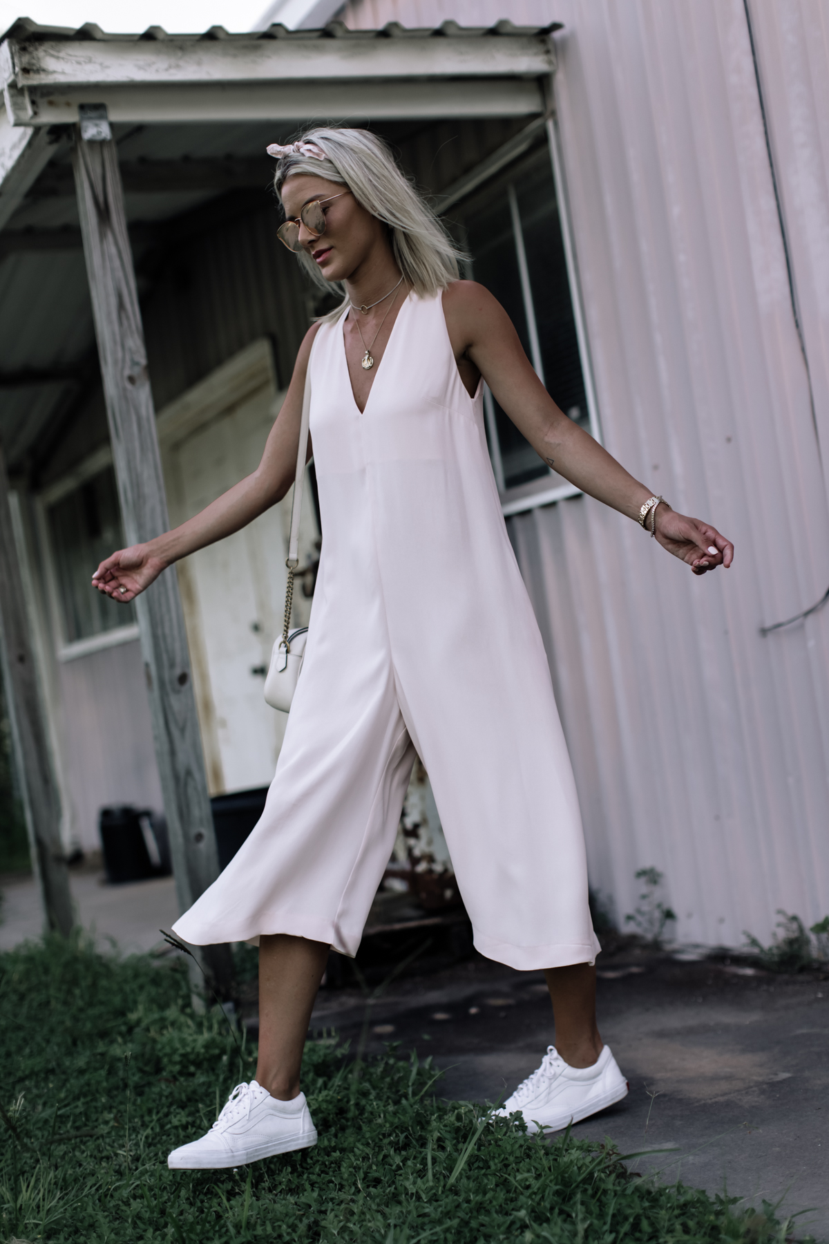 blogger Sage Coralli in light pink jumpsuit festival outfit
