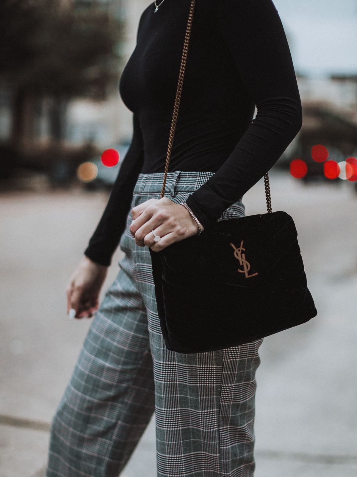 Sage Coralli wearing a black velvet YSL bag with gold hardware