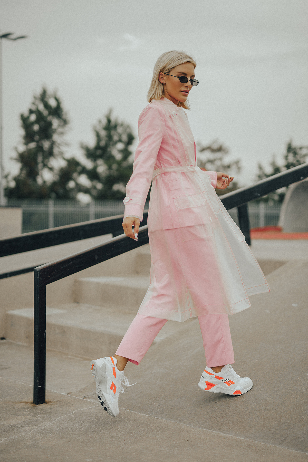 Blogger Sage Coralli wears the Reebok Aztrek sneakers and a pink power suit