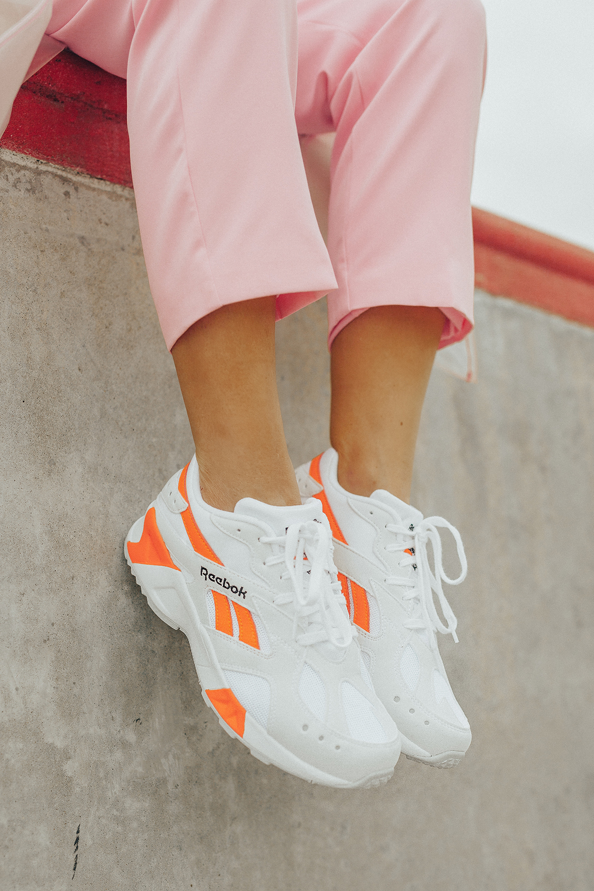 Orange and white Reebok Aztrek Sneakers on Sage Coralli
