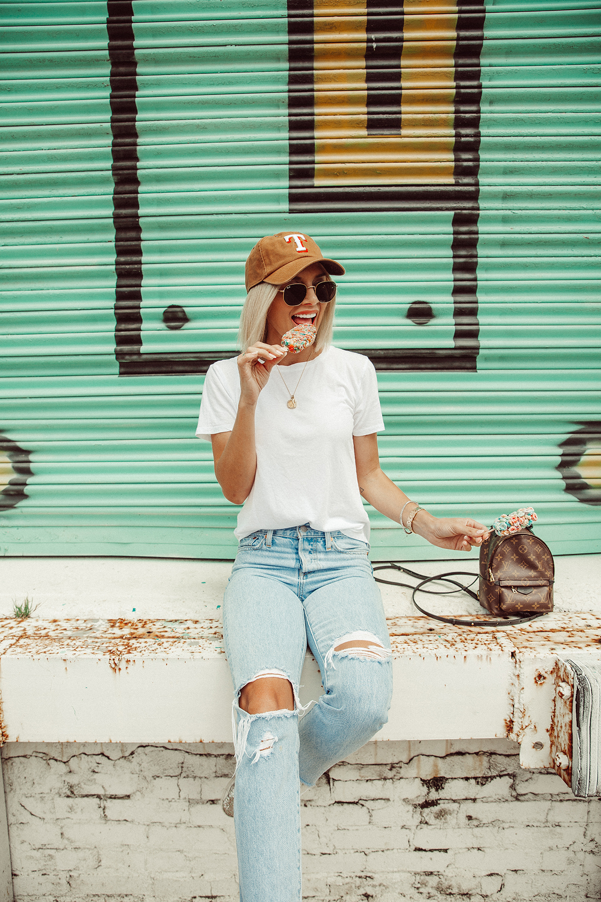 Blogger So Sage wearing a casual summer outfit with a baseball cap